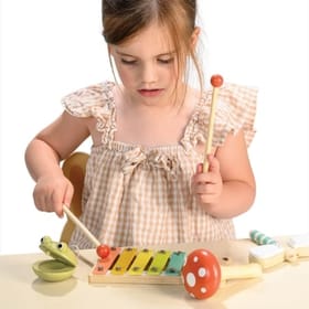 Young Girl Playing with a Woodland Music Set