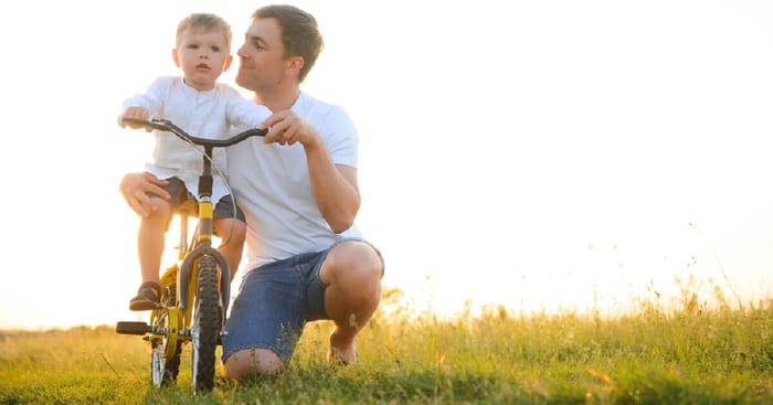 Farther helping son ride a bike