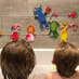 Children looking at bath time stickers on the bathroom wall